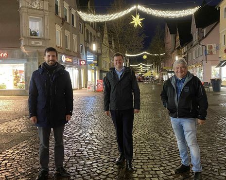 ES LEUCHTET UNTERM HELLENSTEIN: Ruven Becker, Oberbürgermeister Michael Salomo und Charles Simon (von links) bewundern die Weihnachtsbeleuchtung in der Fußgängerzone. Foto: Stadt Heidenheim